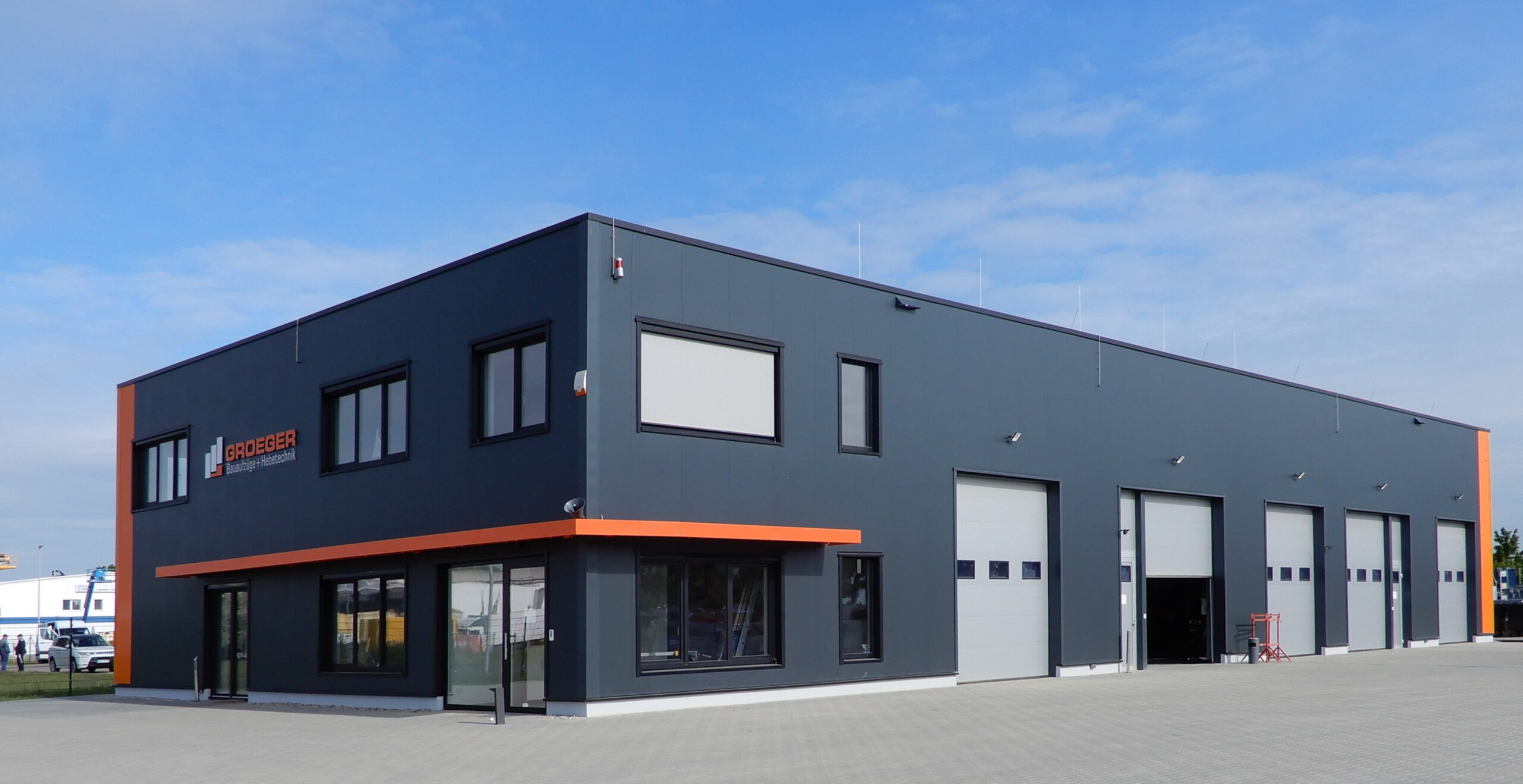 Schwarze Betriebshalle mit Orange bei Sonnenschein in Vogelsdorf